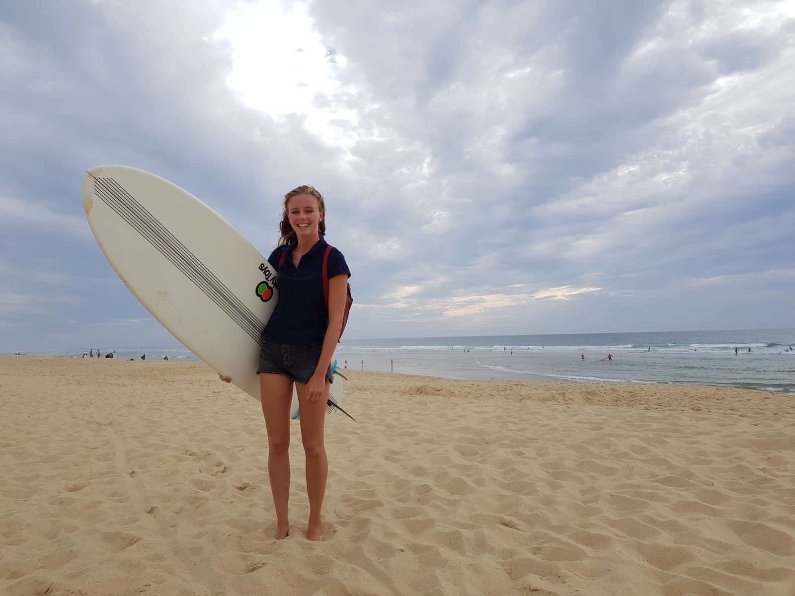 Tiener met surfboard op het strand - op weg naar zelfstandigheid